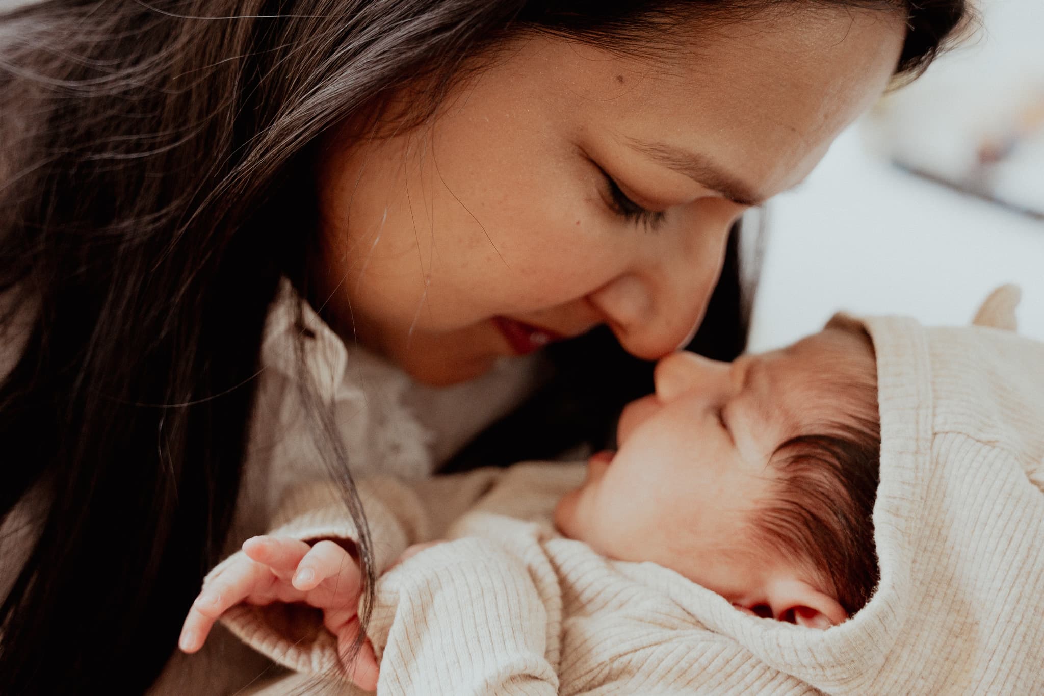 Mother touching her nose to her newborn’s face